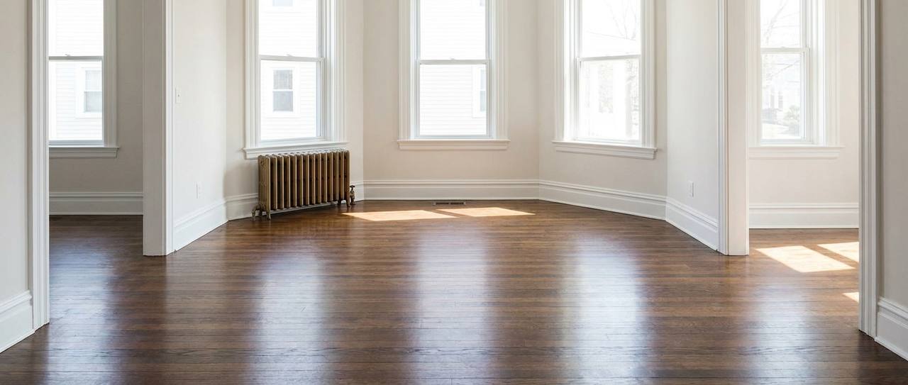 Empty broom-clean living room with original hardwood floors, the goal state of an estate cleanout